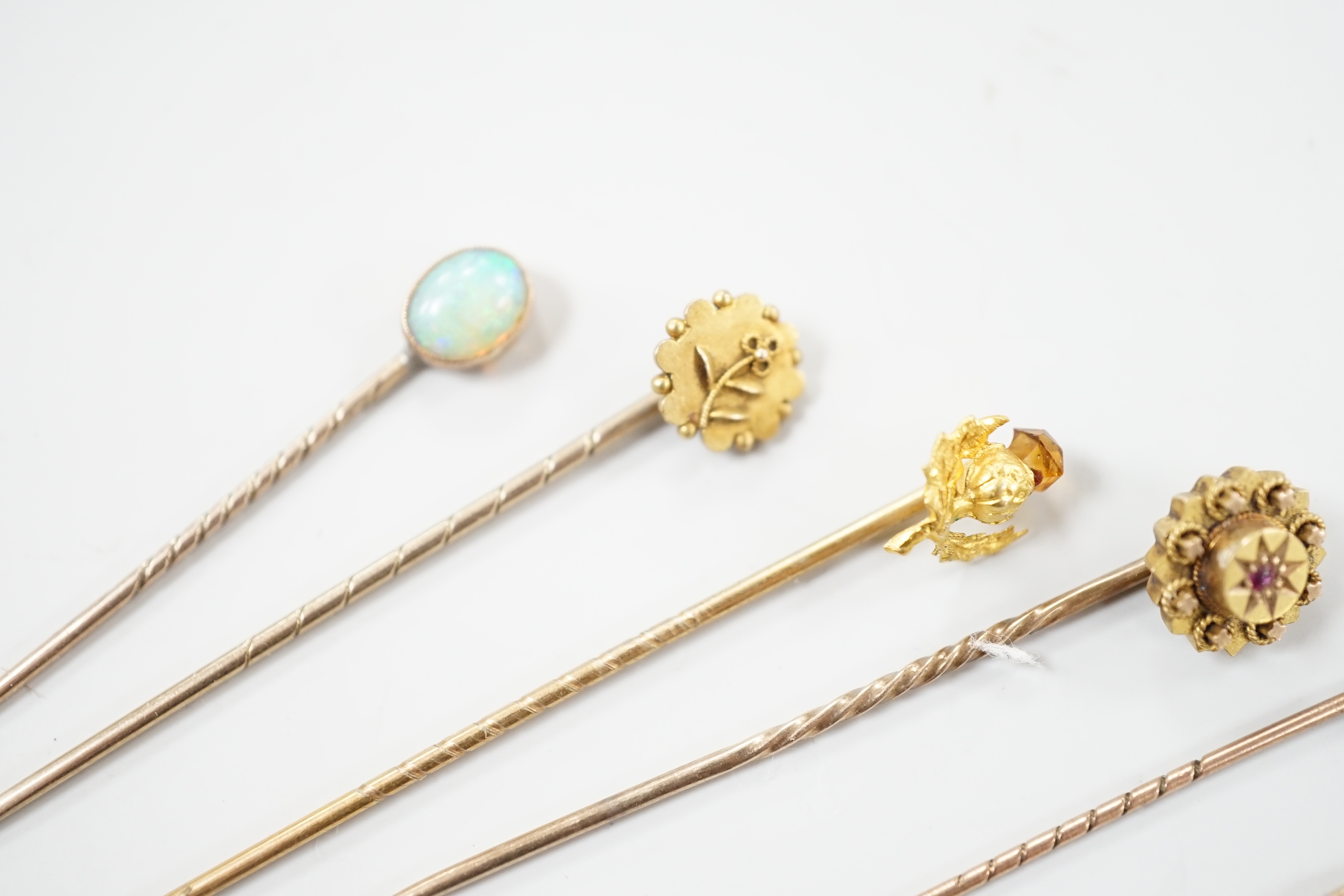 Three early 20th century 15ct stick pins including gem, three similar 9ct stick pins and one other yellow metal and white opal set stick pin, largest approx. 57mm.